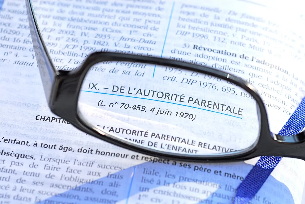 Gros plan sur un texte légal relatif à l'autorité parentale, représentant les aspects juridiques liés à la protection des droits des enfants et des mineurs. ​​