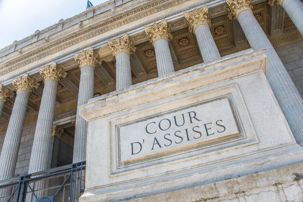 Entrée de la Cour d'assises avec colonnes majestueuses, symbolisant la justice et le droit public.