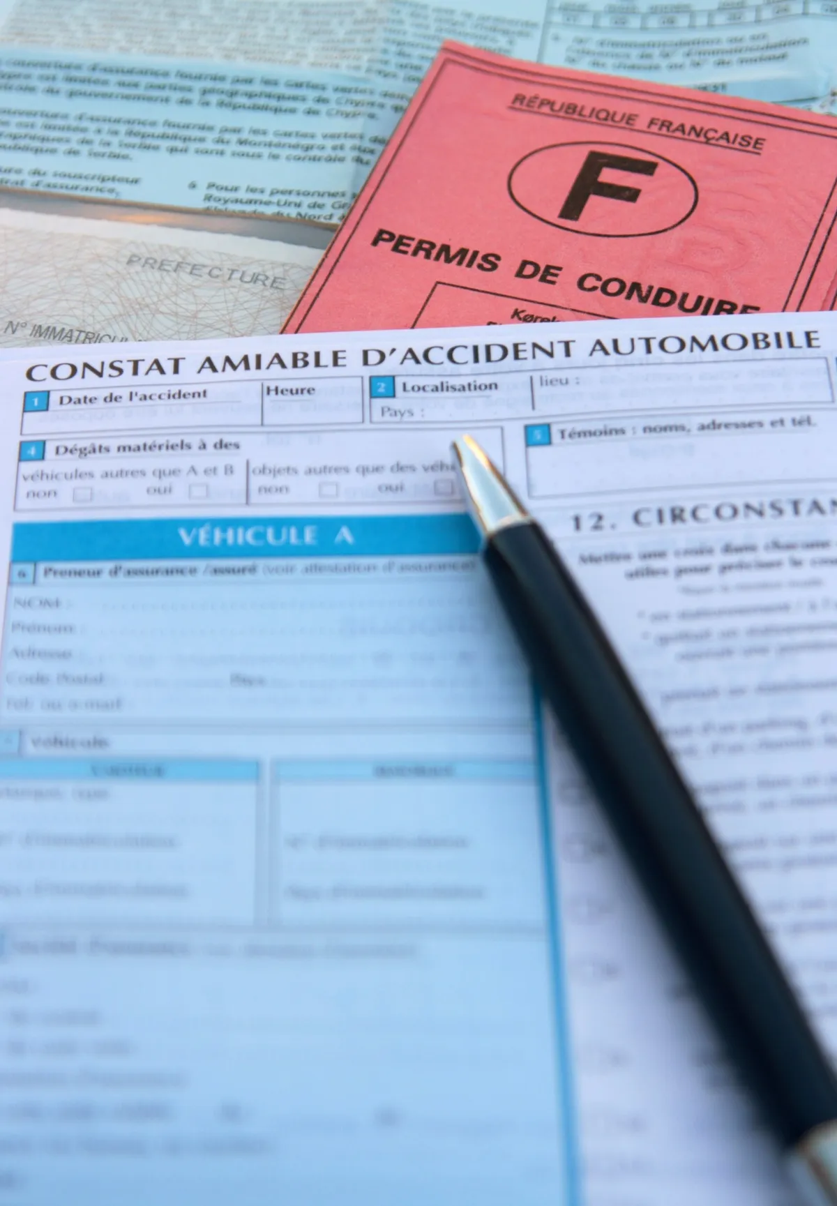 Image de documents administratifs liés au droit routier, incluant un permis de conduire français et un constat amiable d'accident.